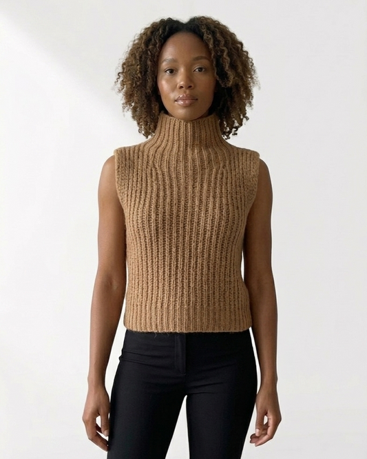 South African model wearing sleeveless golden beige chunky knit turtleneck vest with long beaded necklace and green tassel. High neck ribbed sweater showcases South African craftsmanship, Studio Minimale